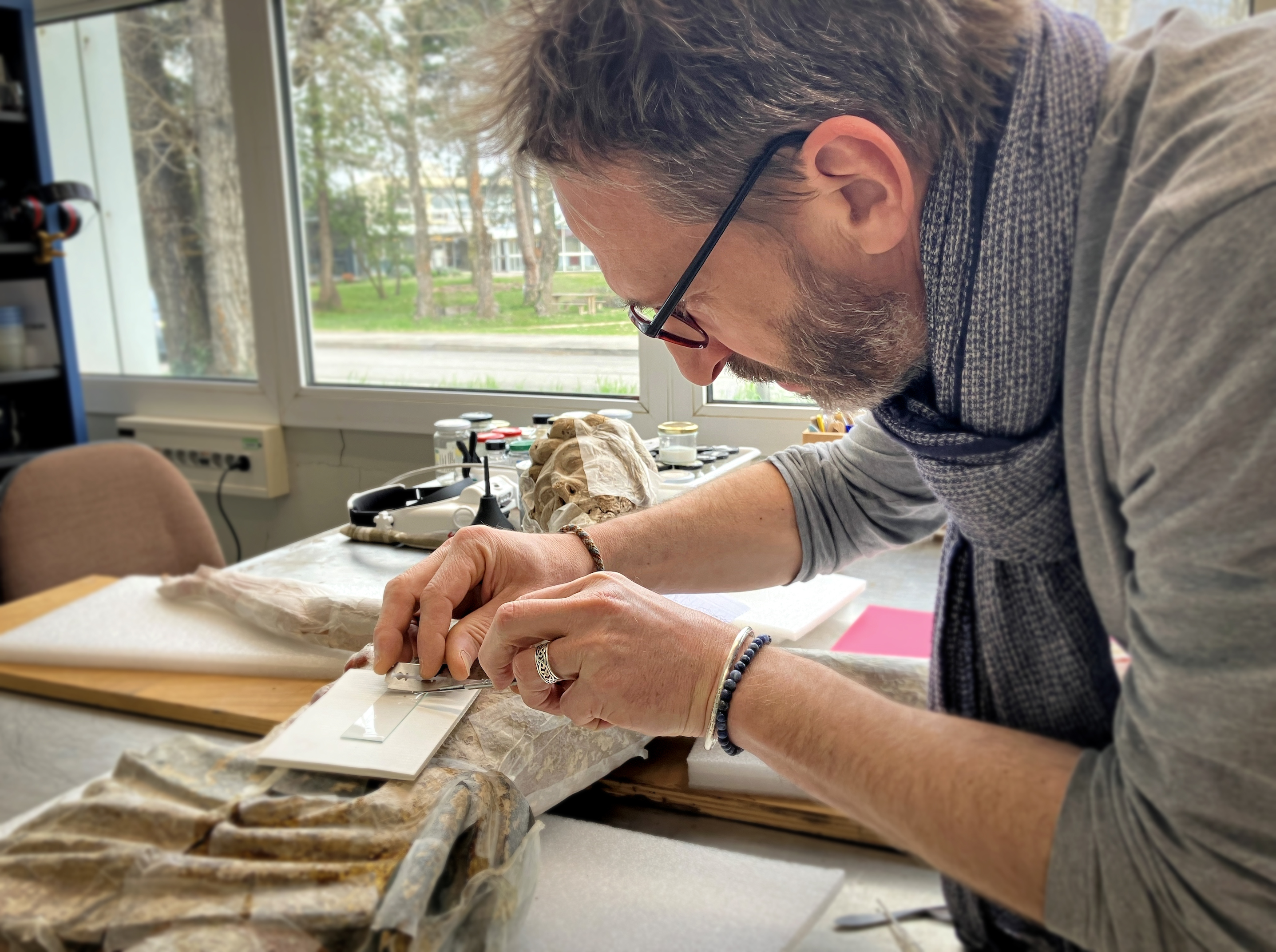 Didier Pousset examinant une sculpture au laboratoire